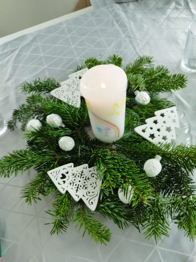Winterdeko Grüne Tannenzweige mit Kerze, kleinen weißen Kugeln und drei gegossenen weißen Tannenbäumen