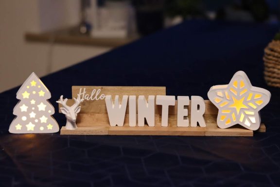 Beleuchtete Winterdeko Textdeko aus Buchstaben die WINTER ergeben, mit Hirschkopf, beleuchteten Tannenbaum und Schneeflocke