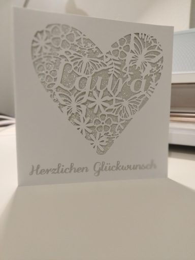 Individuelle Geburtstagskarte Geburtstagskarte, quadratisch, in weiß mit Silbernen Elementen, ein Herz mit Blumen und Schmetterlingen, in der Mitte steht Laura