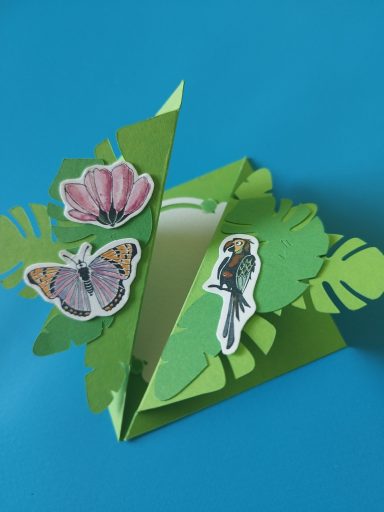 3D Karte 3D Karte in Dschungel Optik, grüne Karte mit rausragenden Dschungelblättern und mit Schmetterlingen, Papagei und Blumen.