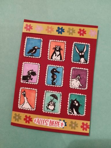 Karte mit Alles Liebe Karte mit 9 bestempelten Tieren in Briefmarken, Untergrund rot mit gelbem Blumenrand. Text Alles Liebe